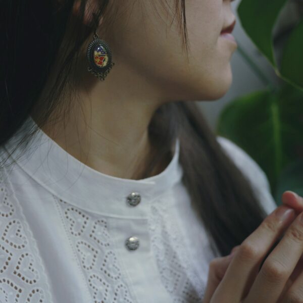 Boucles d'oreilles artisanales de style victorien et japonais portées par une jeune fille.