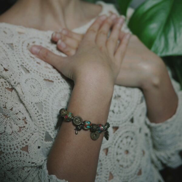 Photo d'un bracelet artisanal ethnique d'inspiration tibétaine et népalaise au poignet d'une femme.
