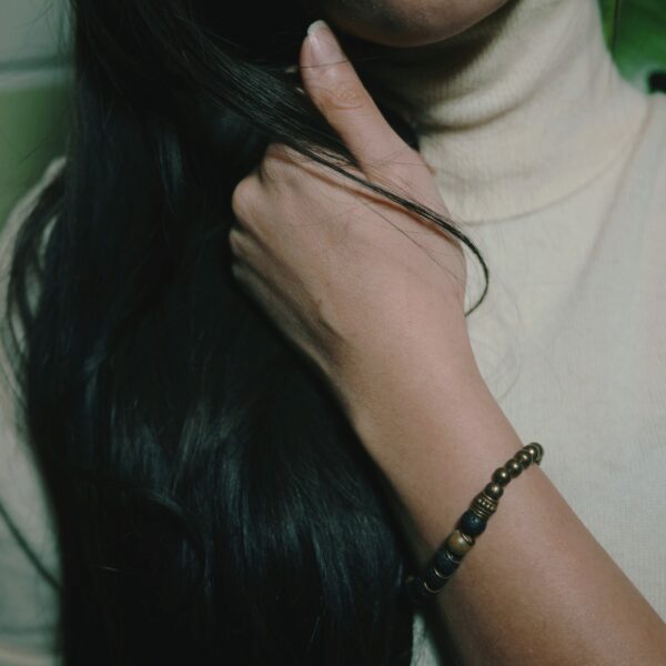 Photo d'un bracelet indien artisanal porté au poignet, fait de pierres semi-précieuses de lave et de bois de santal.