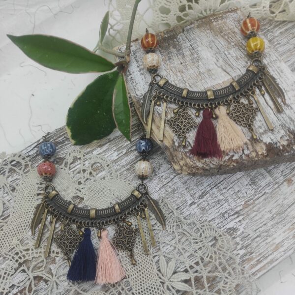 Photo générale de colliers artisanaux de style ethnique, folklorique composé de perles de céramiques japonaises et de pompons de coton.