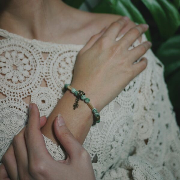 Photo d'un bracelet de style vintage et coréen fait de pierres semi-précieuses de jaspe et de nacre, porté au poignet.
