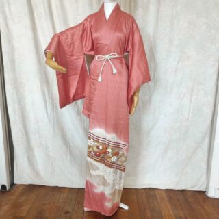 Photo d'un kimono japonais de couleur rose saumon en soie avec des broderies au fil d'or