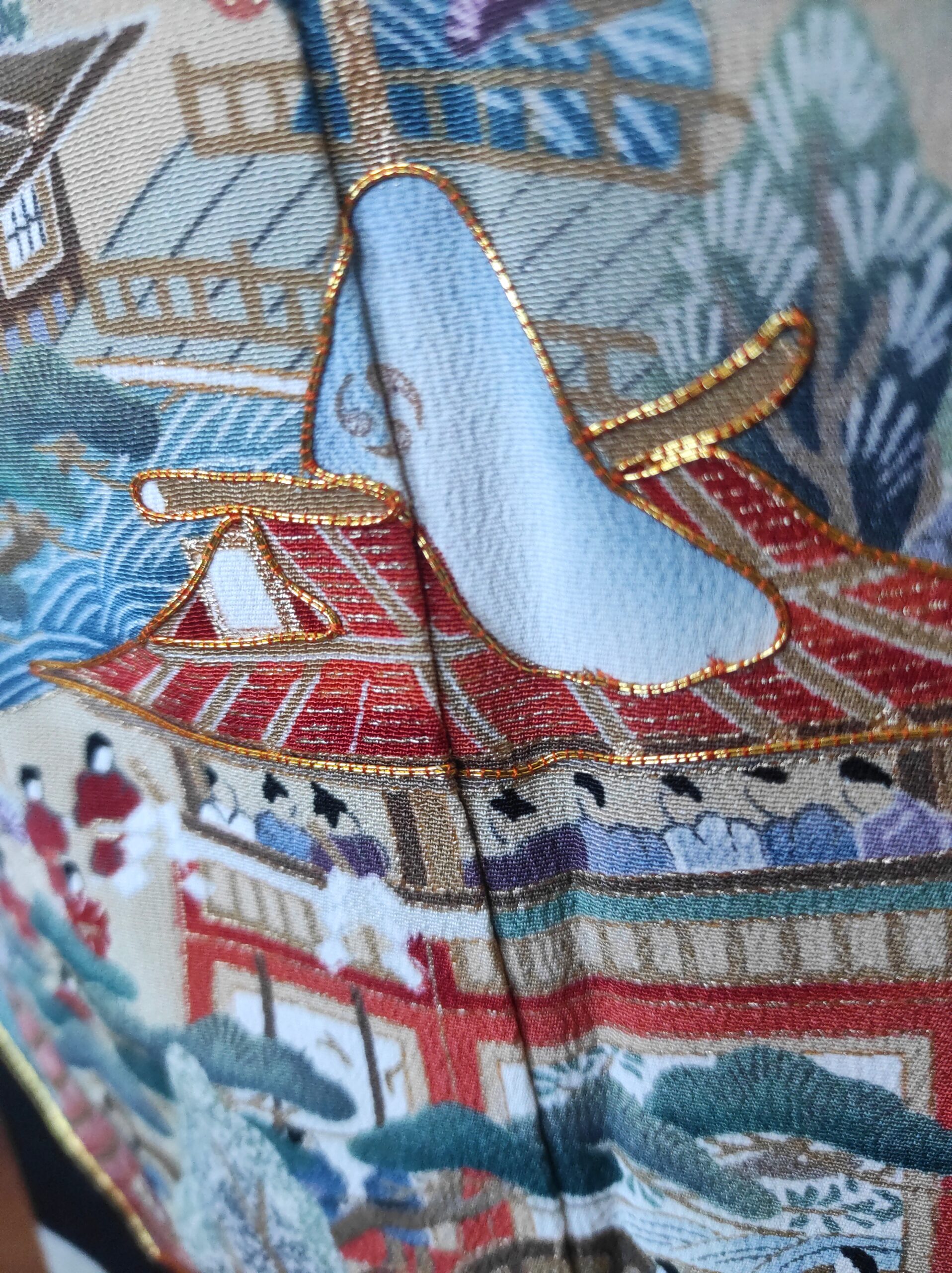 Image rapprochée de la peinture et des broderies faites sur un kimono japonais en soie.