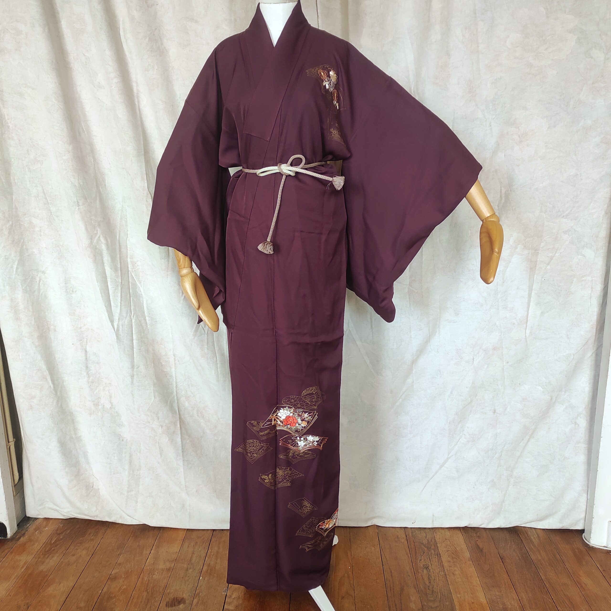 Un kimono violet brodé de livres ouverts au fil d'or