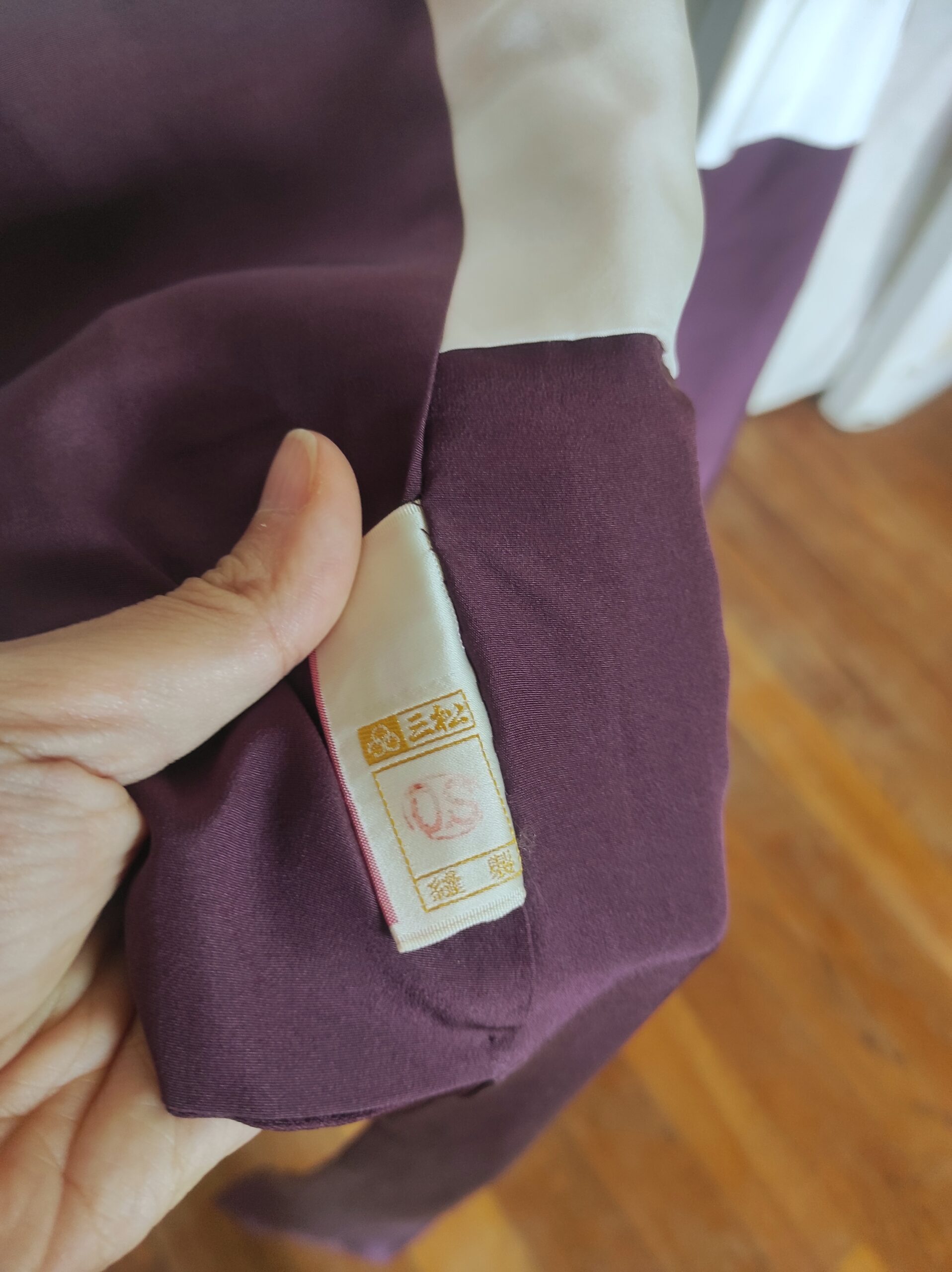 Photo rapprochée d'une étiquette de kimono japonais de luxe comportant le sceau de l'artisan qui l'a confectionné