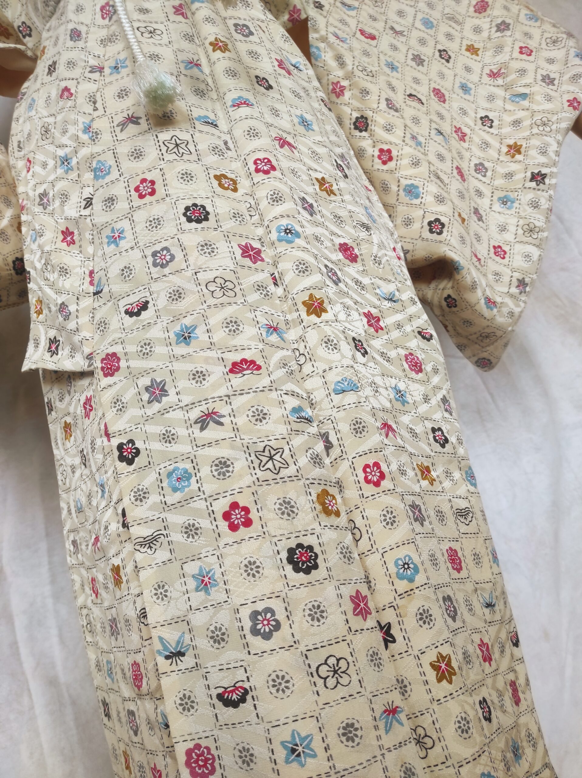 Photo du bas d'un kimono japonais de cérémonie en soierie au design de fleurs et éléments naturels japonais