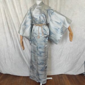 Photo rapprochée d'un kimono japonais vintage en soie bleue avec motifs irisés et peinture sur soie faite par un artisan