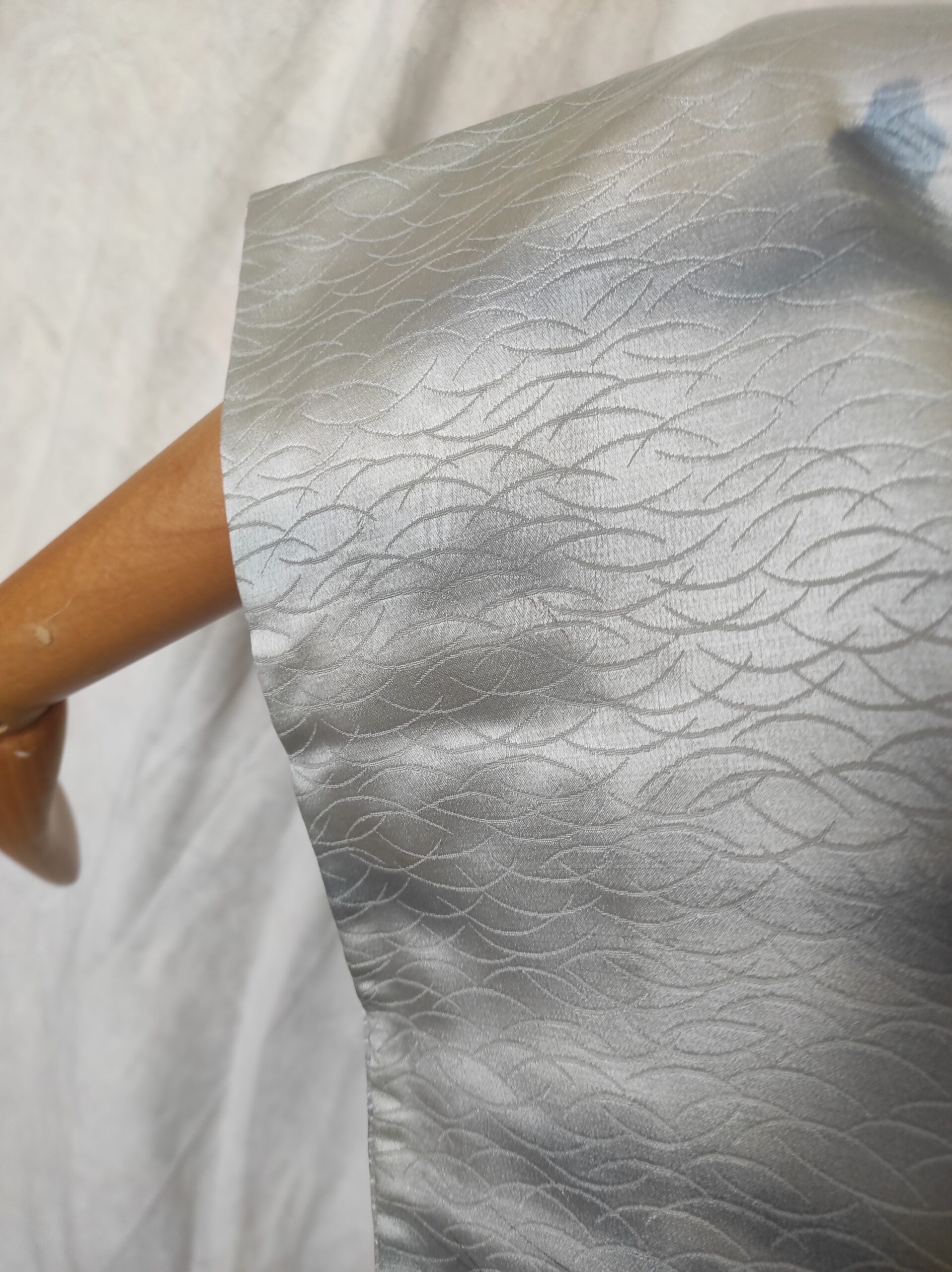 Image de la manche d'un kimono en soie bleu irisé à motif d'herbes traditionnelles