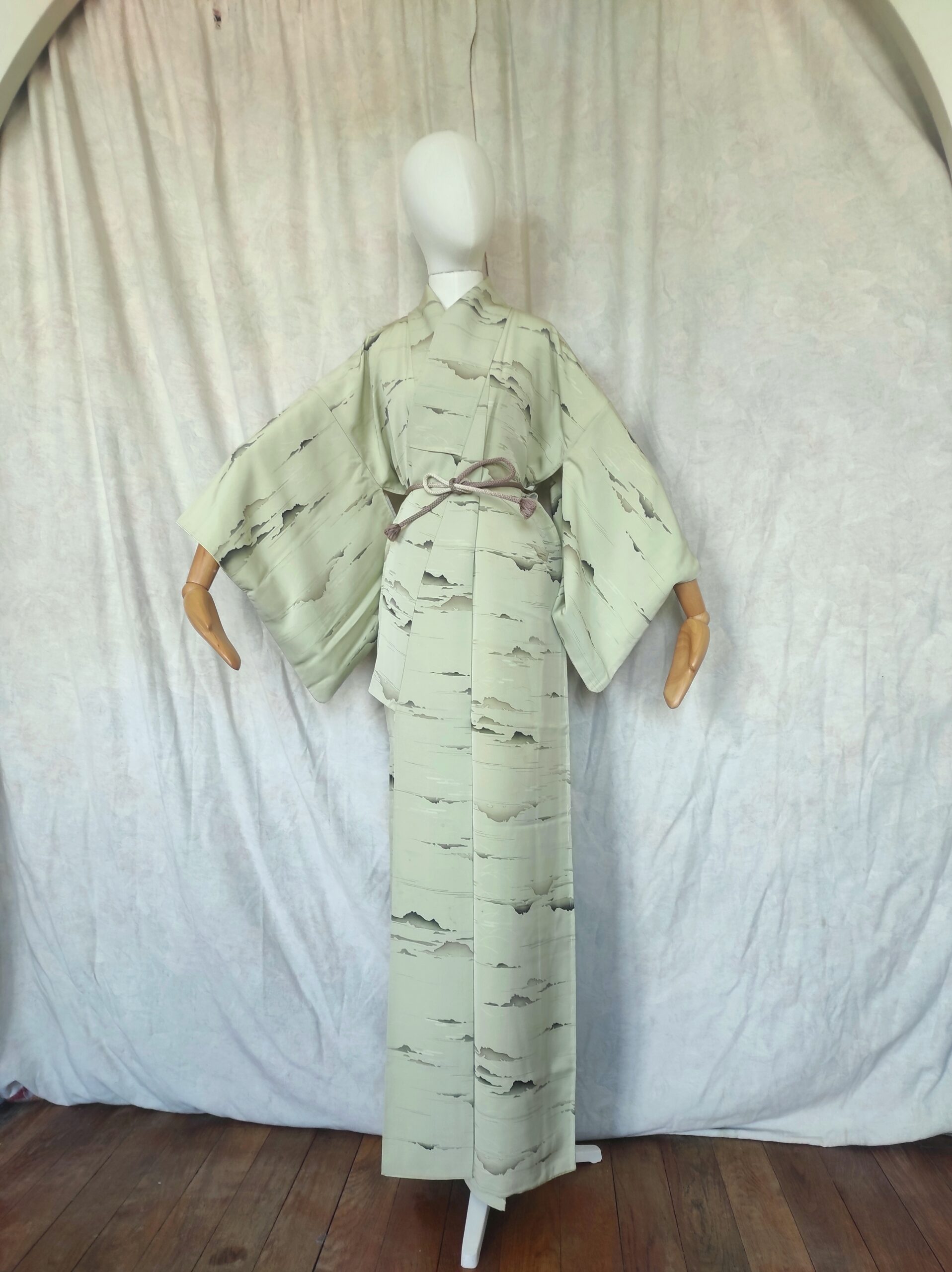 Photo générale d'un kimono de soie vert d'eau et de ses peintures sur soie représentant des montagnes et des nuages
