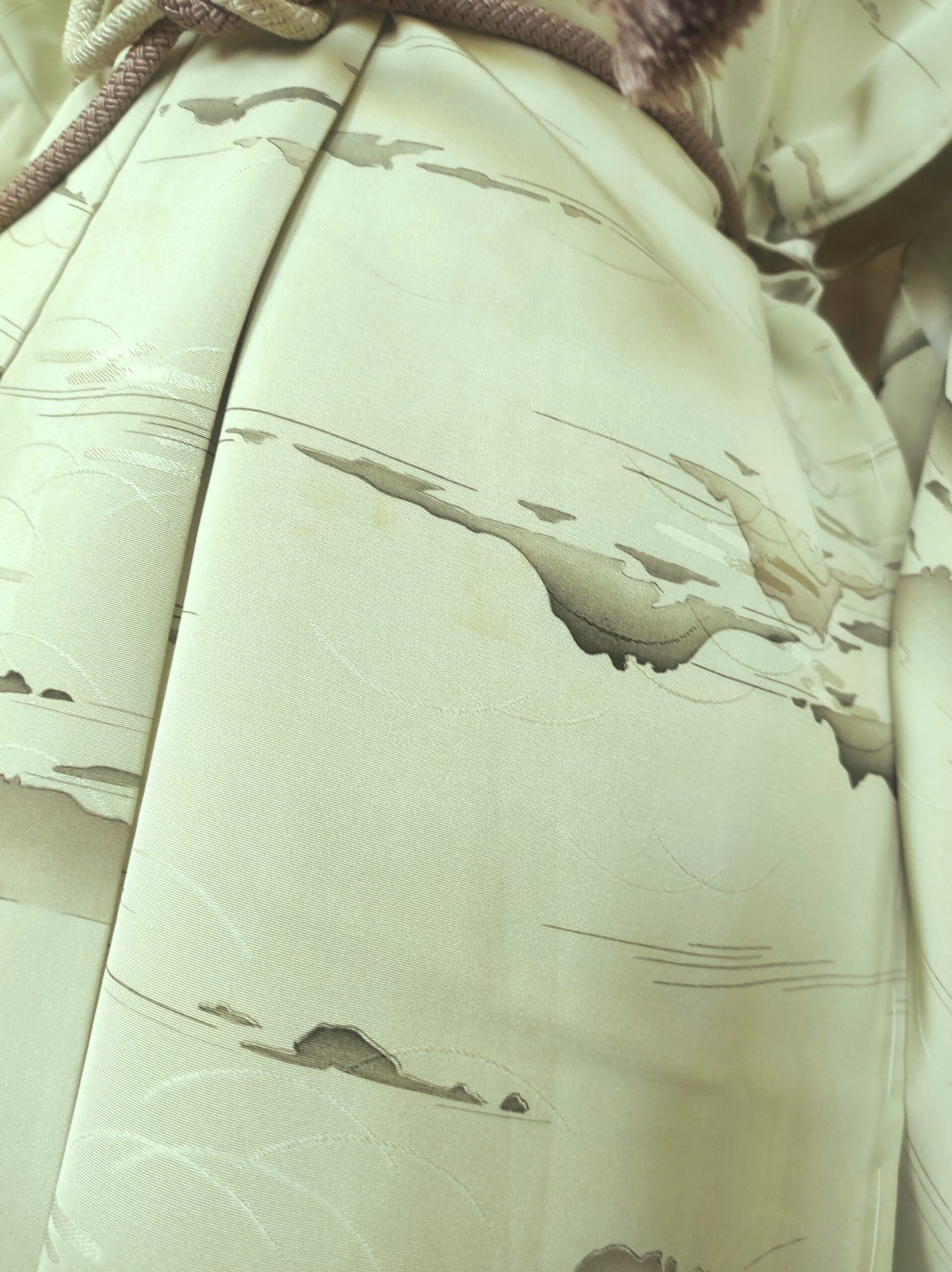 Photo close-up du bas d'un kimono de soie verte comportant des peintures faites à la main par un artisan japonais