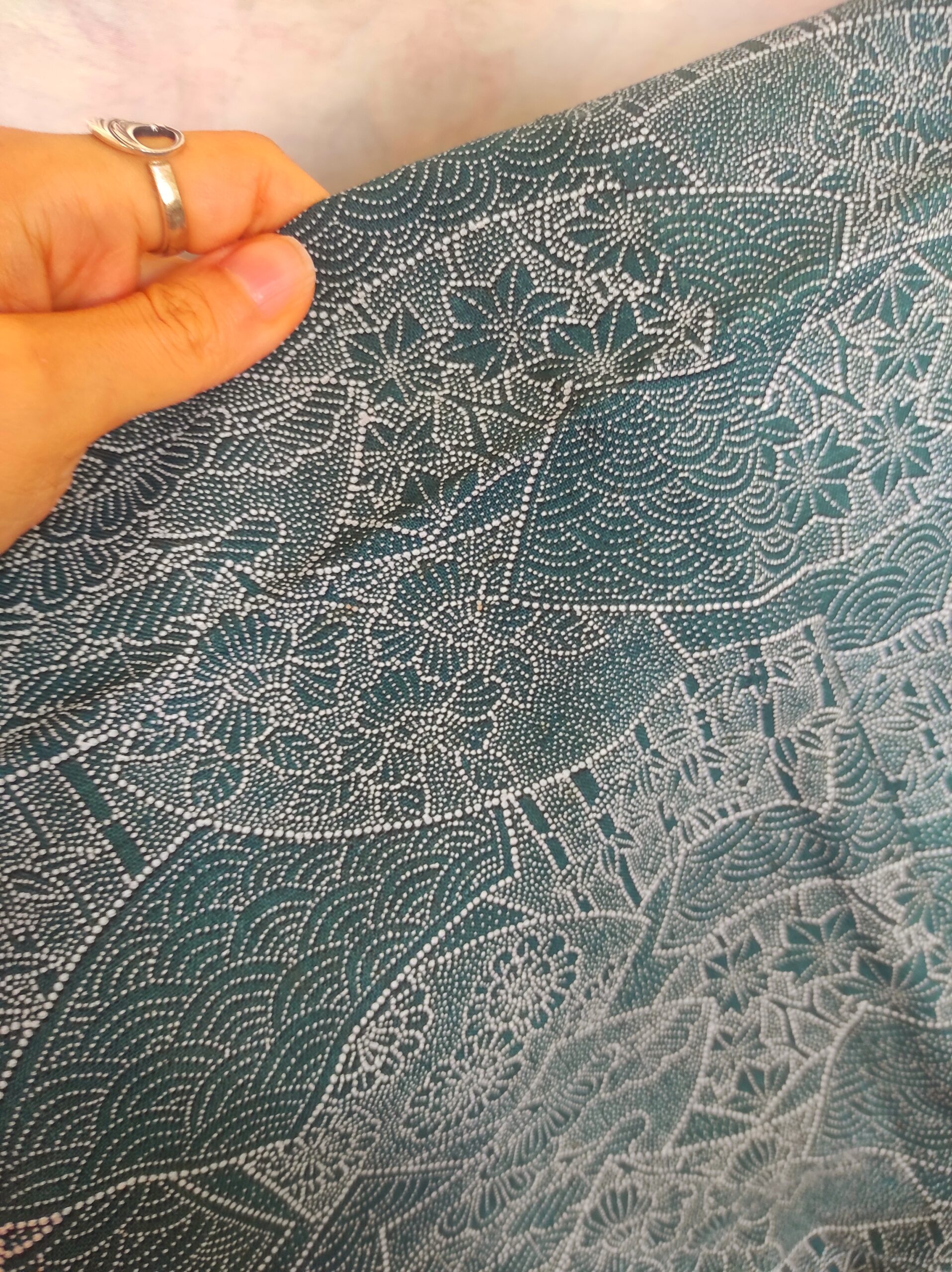 Photo close-up du kimono de laine bleue turquoise et de ses motifs en pointillisme