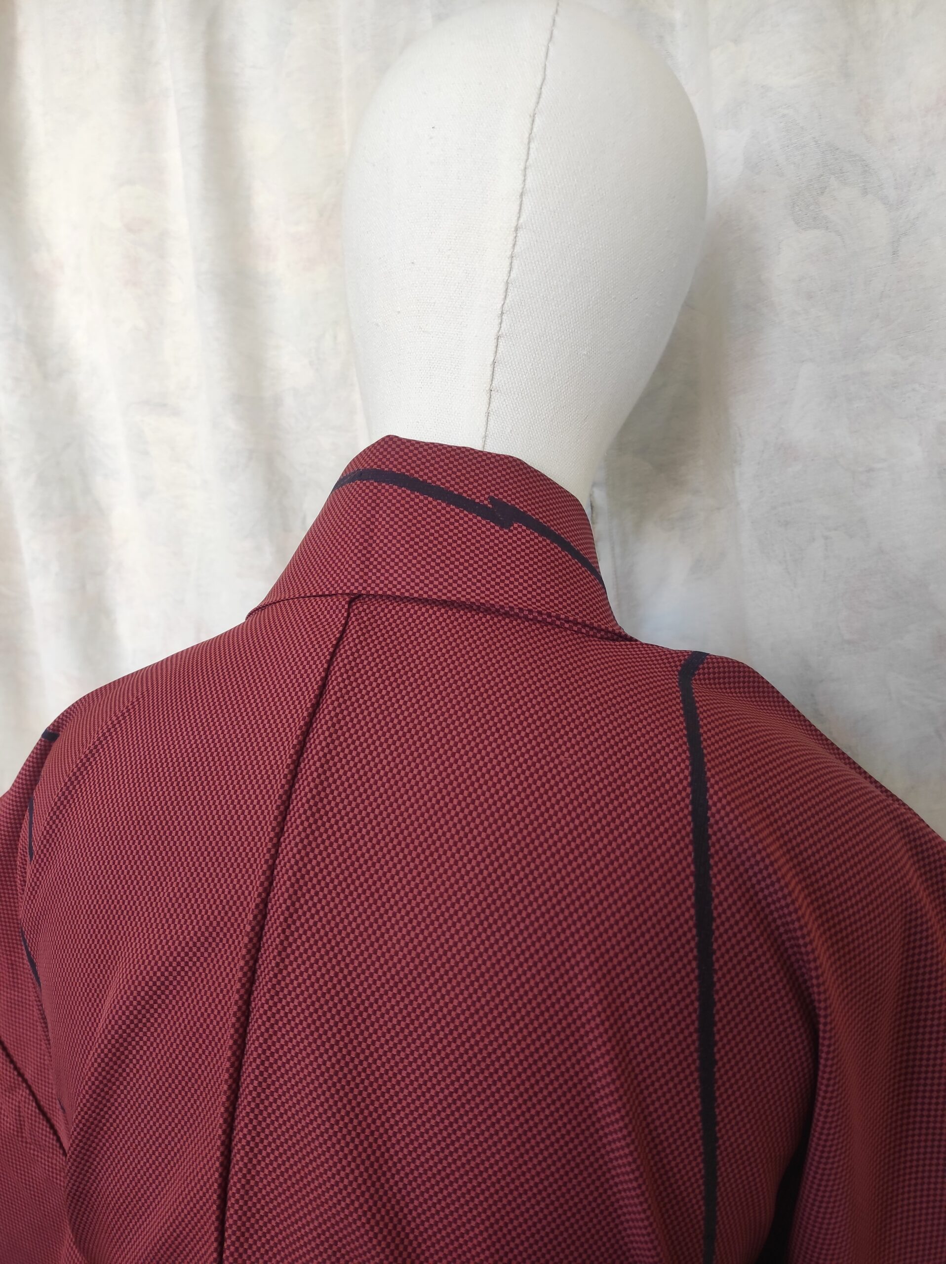 Photo du col d'un kimono de soie rouge composé de motifs géométriques