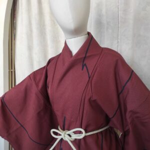 Photo du haut d'un kimono japonais de soie rouge composé de petits carreaux et de motifs géométriques
