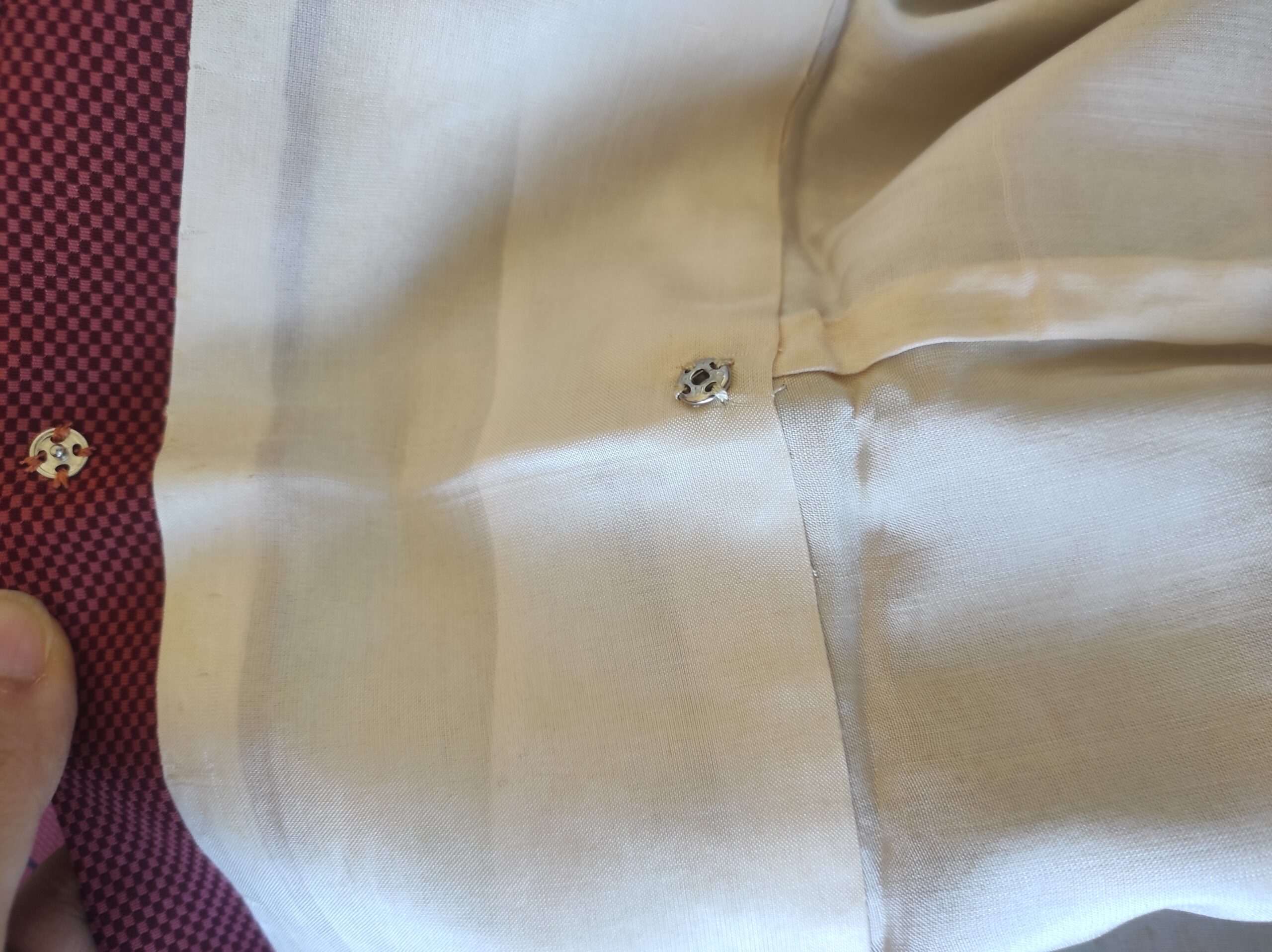 Photo de l'intérieur du col d'un kimono japonais fait de soie rouge et noire et comportant des boutoons-pression