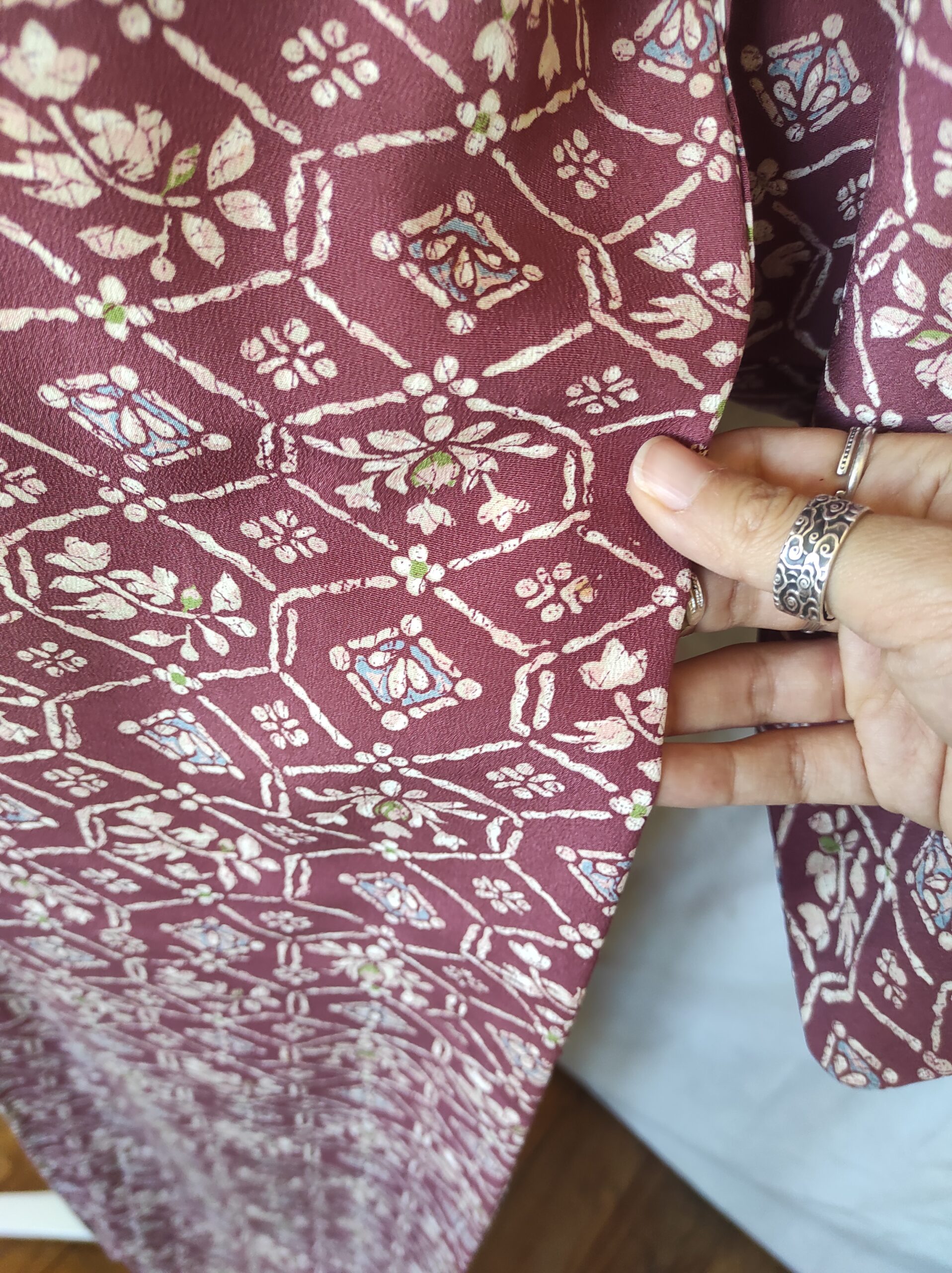 Photo close-up du motif d'un kimono de soie rouge au motif baroque floral et géométrique peint à la main