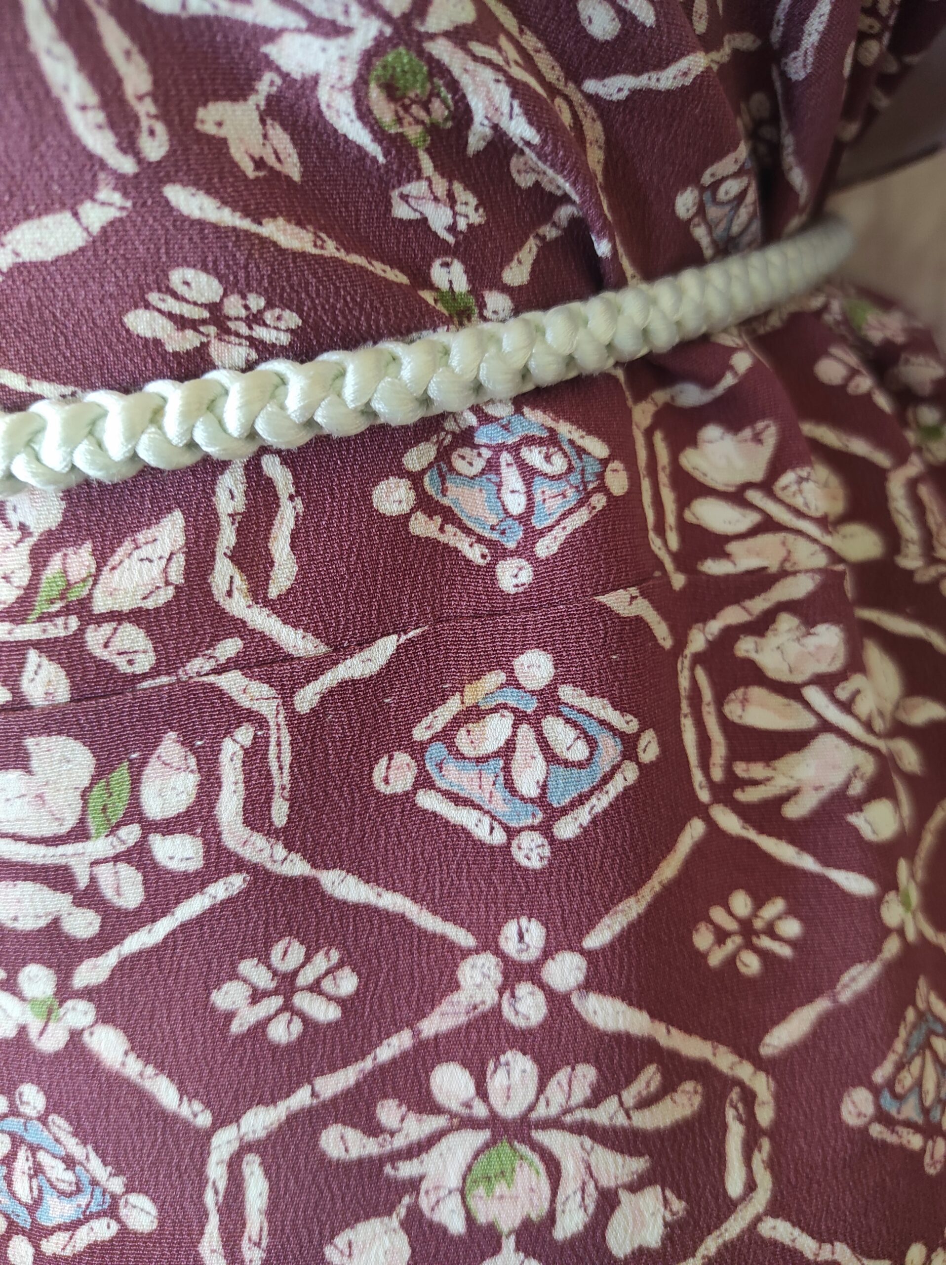 Photographie d'un motif baroque peint à la main sur kimono de soie rouge