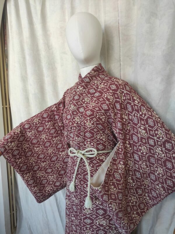 Photographie du haut d'un kimono de soie rouge bordeaux et de motifs baroques traditionnels