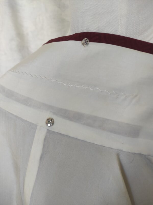 Photo de l'intérieur du col d'un kimono fait de soie blanche et de boutons-pression