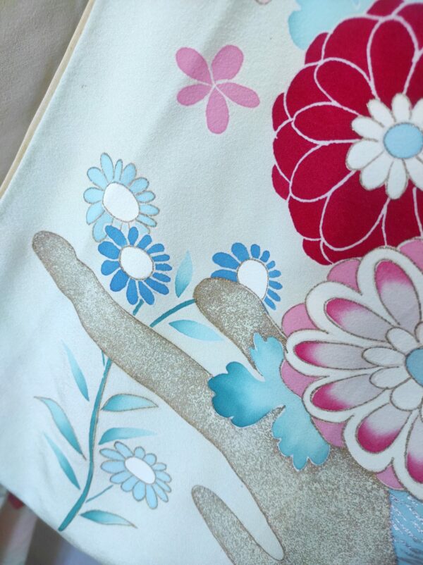 Photo de détails d'un kimono de soie bleu représentant des fleurs peintes à la main sur soie