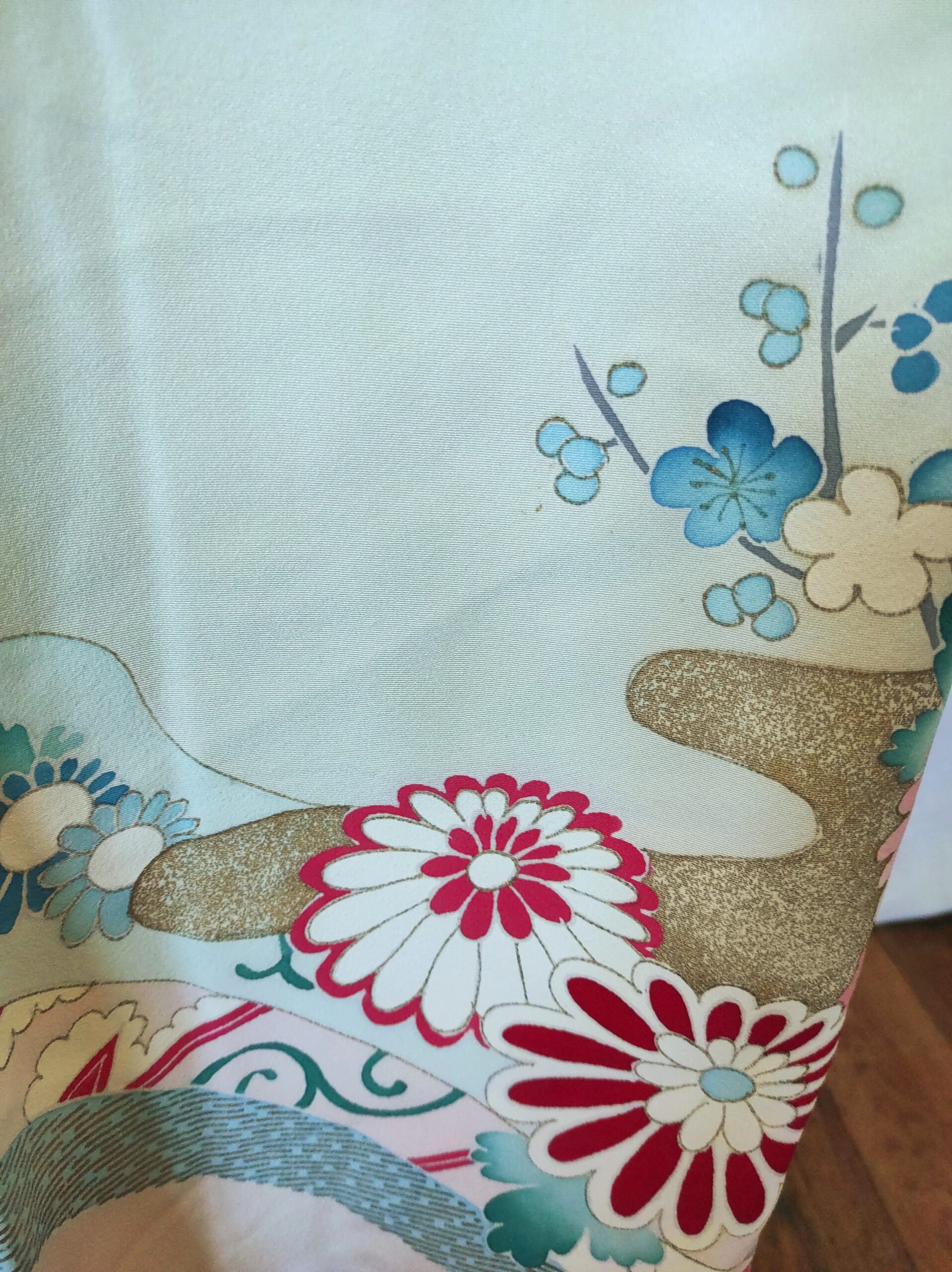 Photo rapprochée d'un kimono japonais vintage de soie sur lequel est peint à la main des fleurs de cerisier et des chrysanthèmes