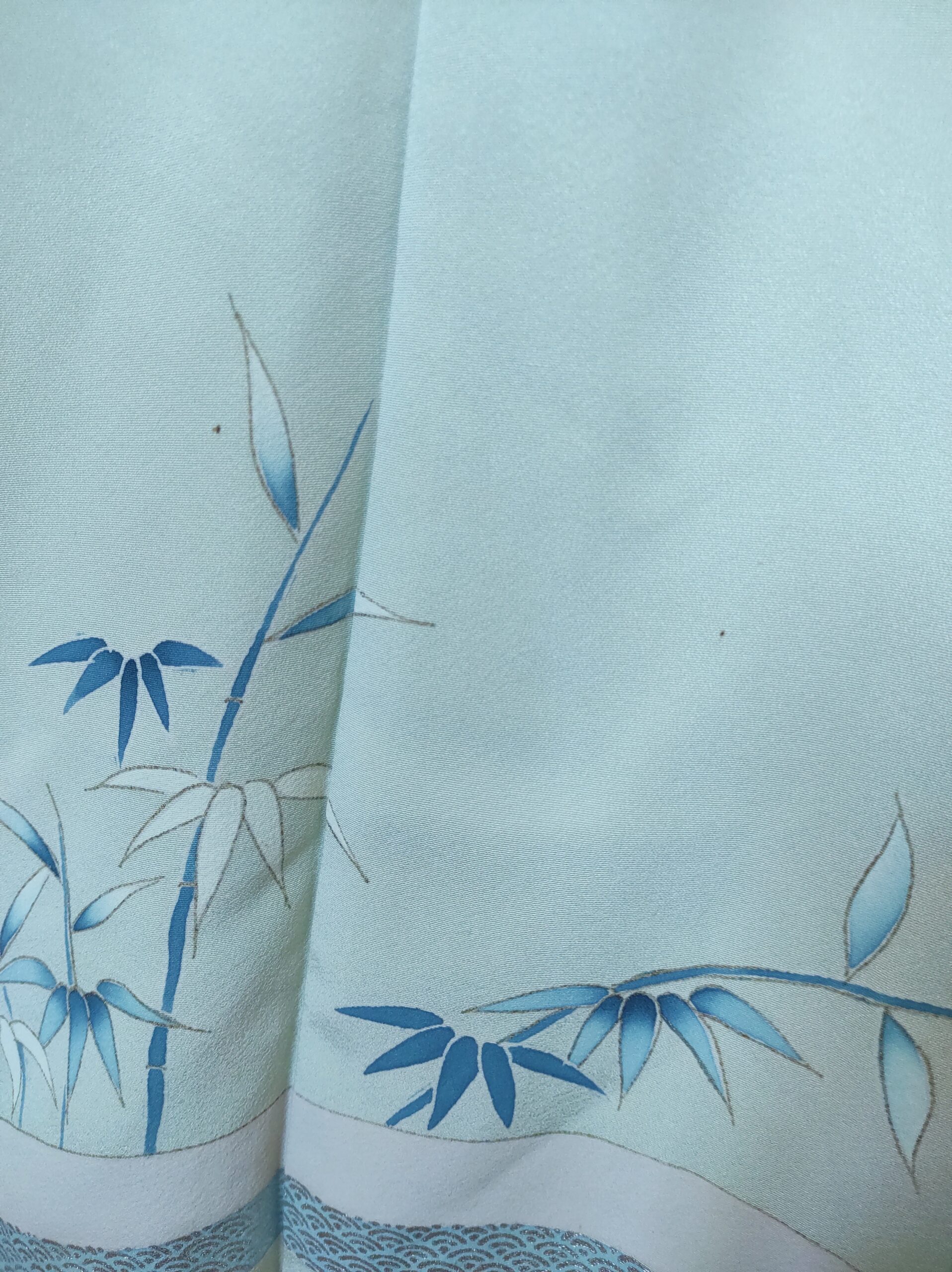 Photo d'un kimono japonais de soie bleu sur lequel est peint à la main des bambous
