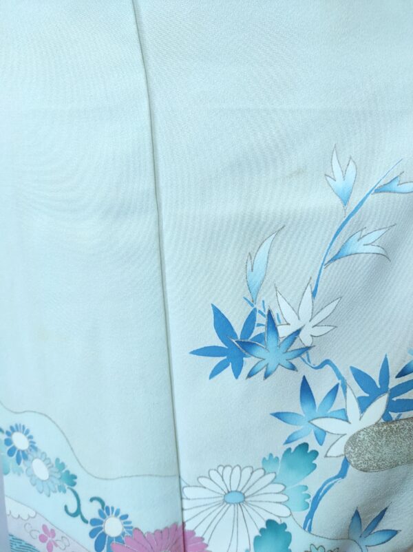 Photo rapprochée d'un kimono japonais de soie bleu comportant des peintures faites main d'érable japonais