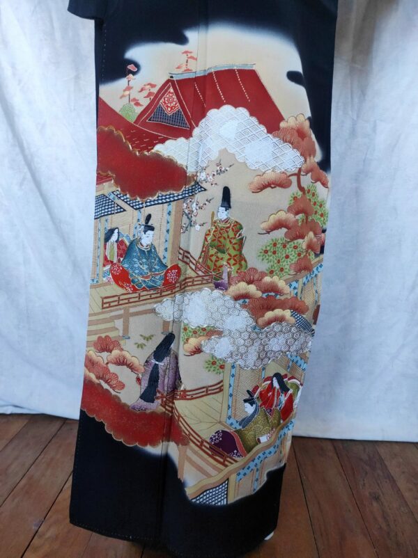 Photographie du bas d'un kimono japonais vintage fait de soie noire sur laquelle est peint un paysage traditionnel