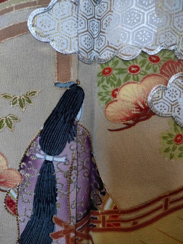 Photo d'une peinture réalisée sur un kimono de soie et représentant une femme de dos et des nuages brodés de fil argenté