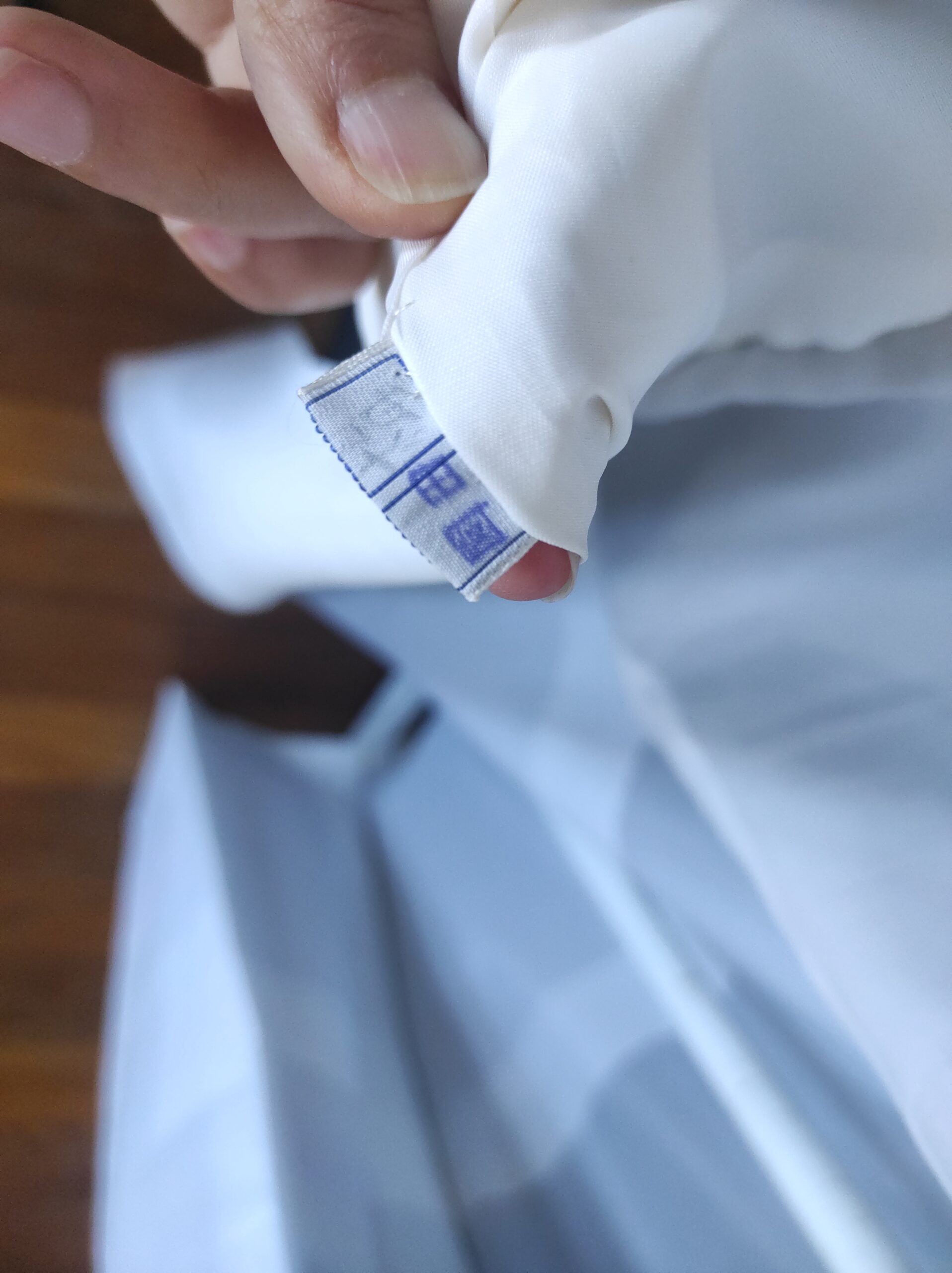 Photographie prise de près d'une étiquette de kimono japonais en soie comportant le sceau de son artisan