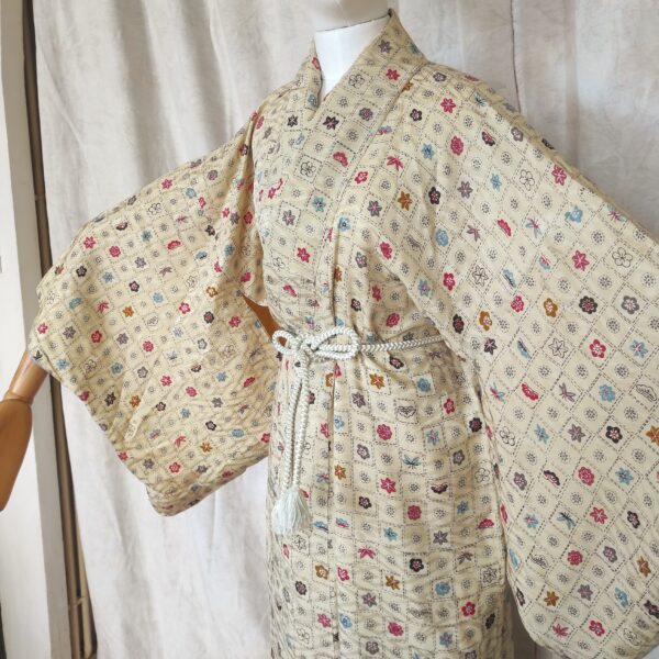 Photographie rapprochée du haut d'un kimono japonais vintage fait de soie crème et de tampons
