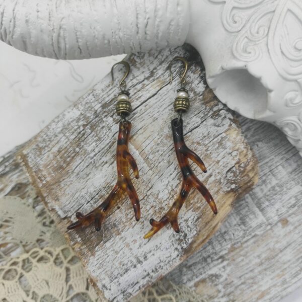Photo de boucles d'oreilles style cornes faites de résine et des pierres de perles de culture