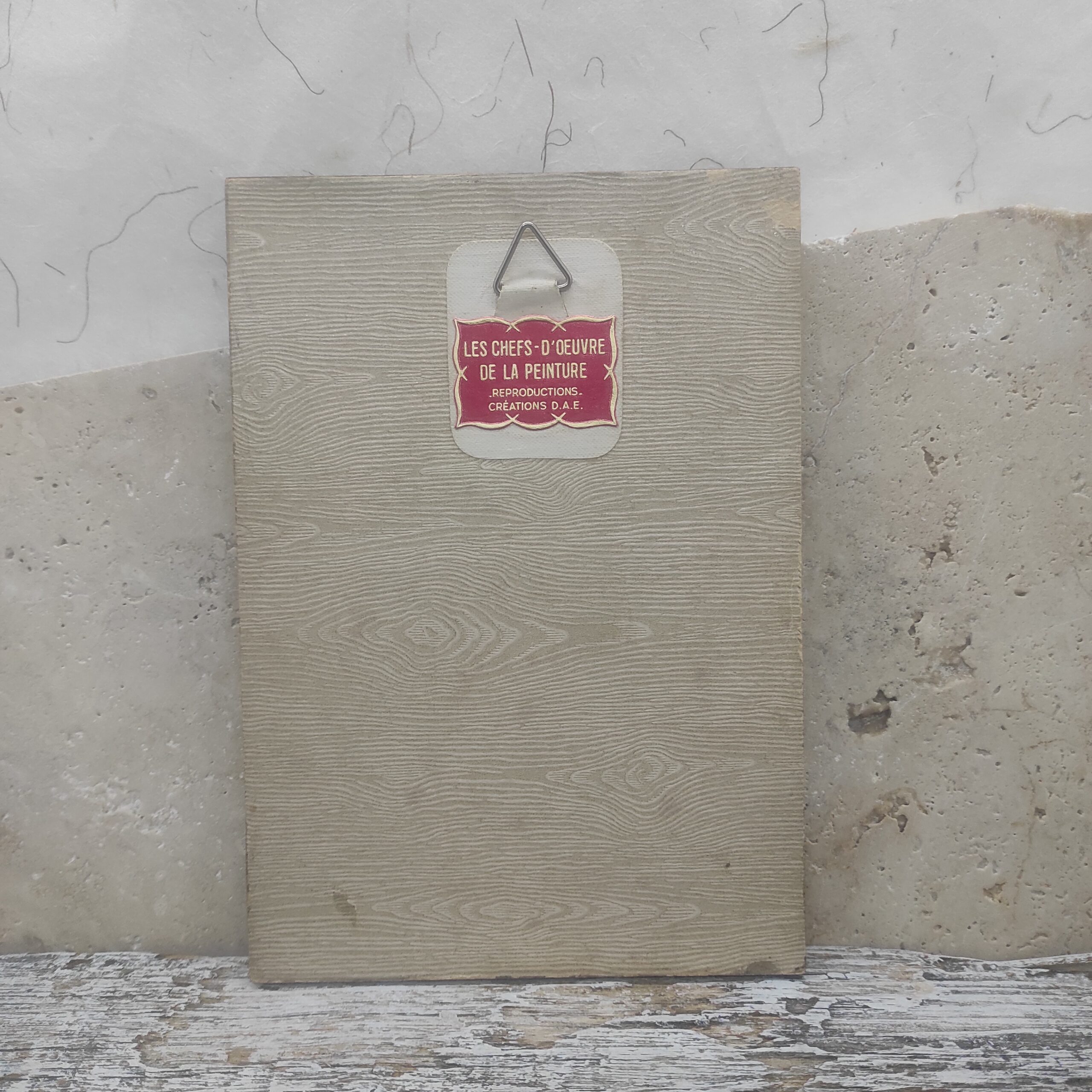 Image de l'arrière d'un cadre photo vintage renfermant un tableau artisanal mystique.