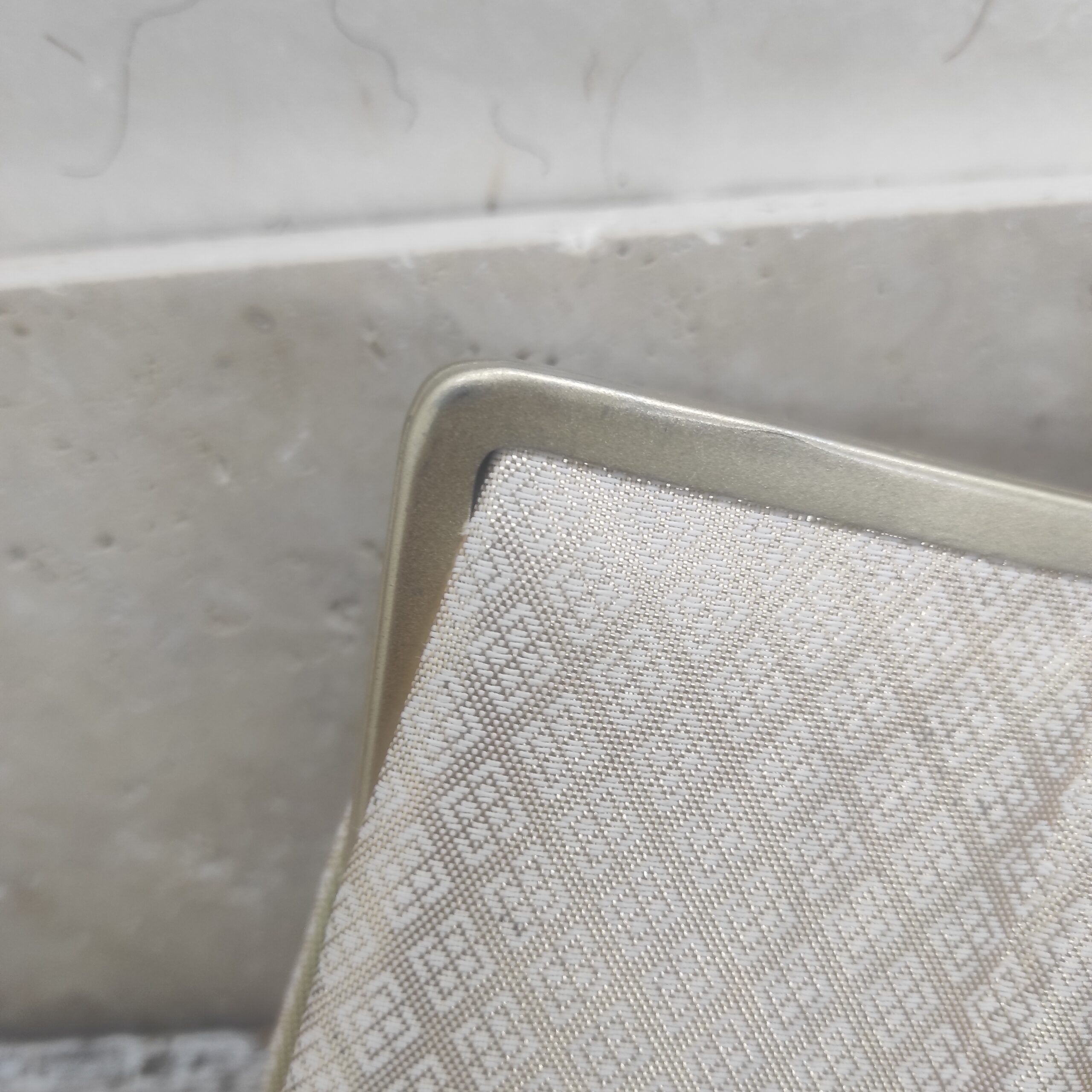 Photographie du coin d'un sac en métal.