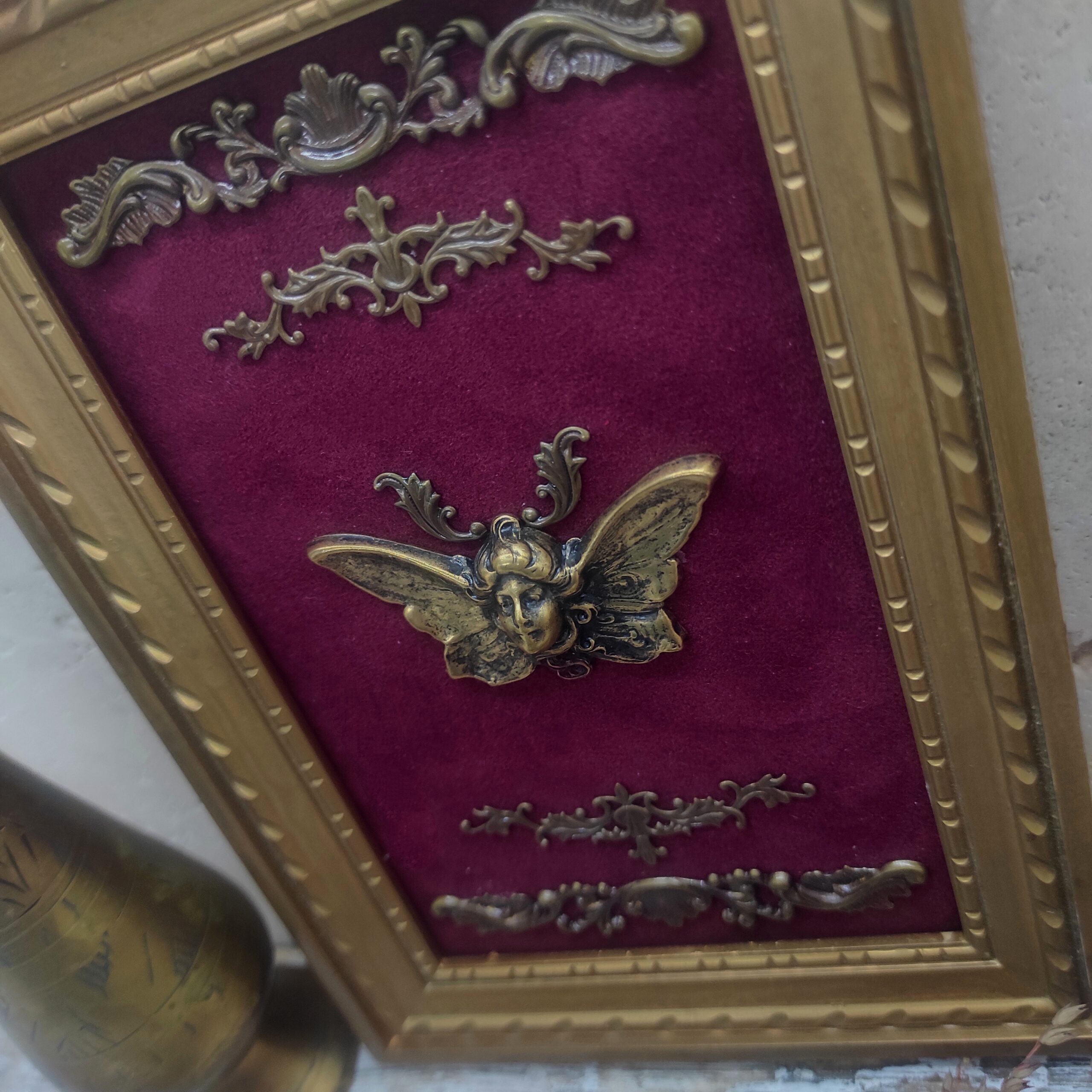 Photo rapprochée d'un cadre vintage recyclé comportant une femme papillon ailée.