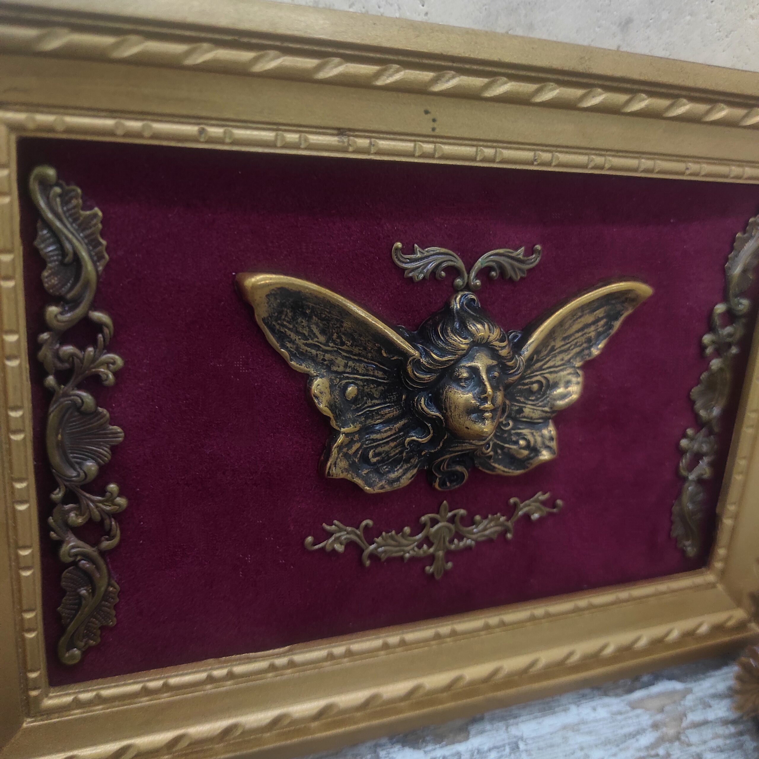 Photo close-up d'un tableau recyclé avec un personnage en laiton ailé.