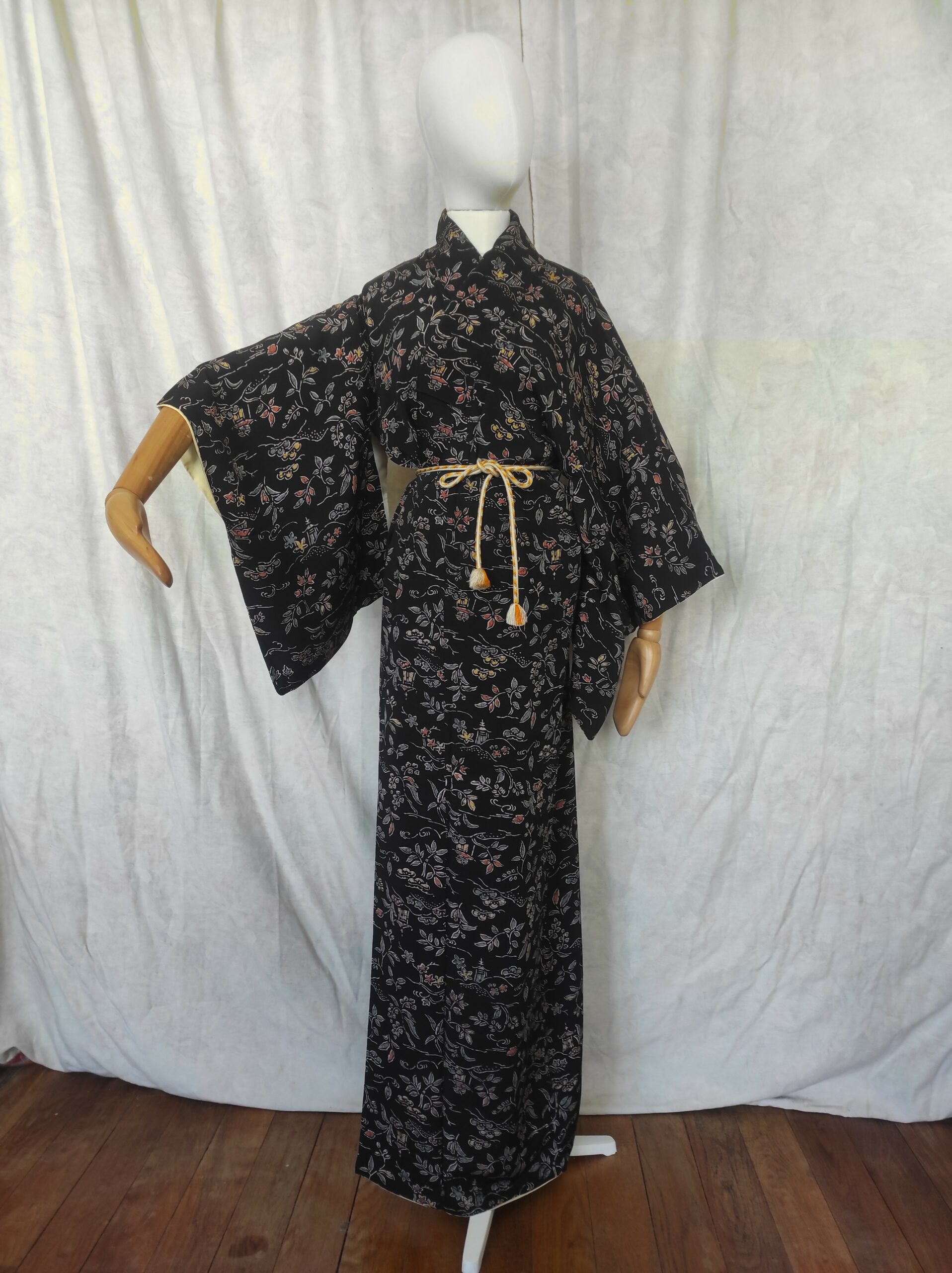 Photographie d'un mannequin en bois portant un kimono japonais en soie noire.