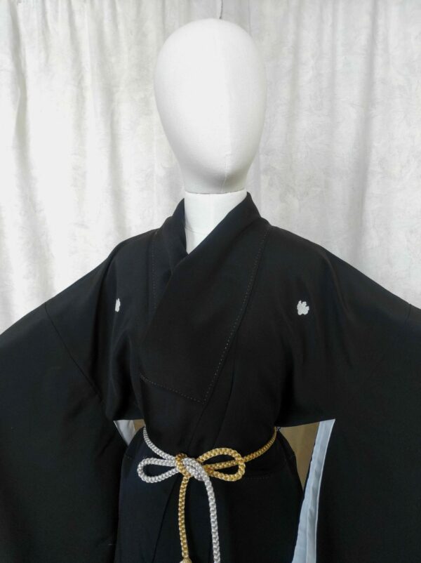 Photo d'un mannequin en bois portant un kimono japonais en soie noire.