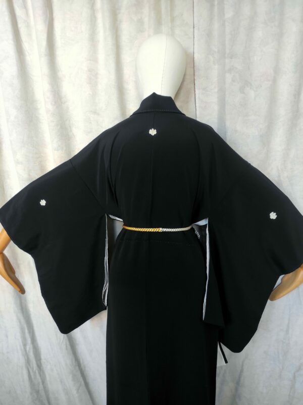 Photographie de l'arrière d'un vrai kimono japonais en soie noire comportant des blasons.