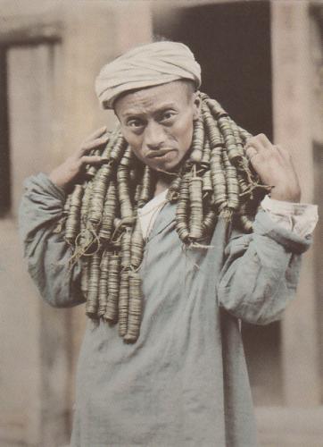 Photo vintage d'un homme chinoise portant des sapèques.