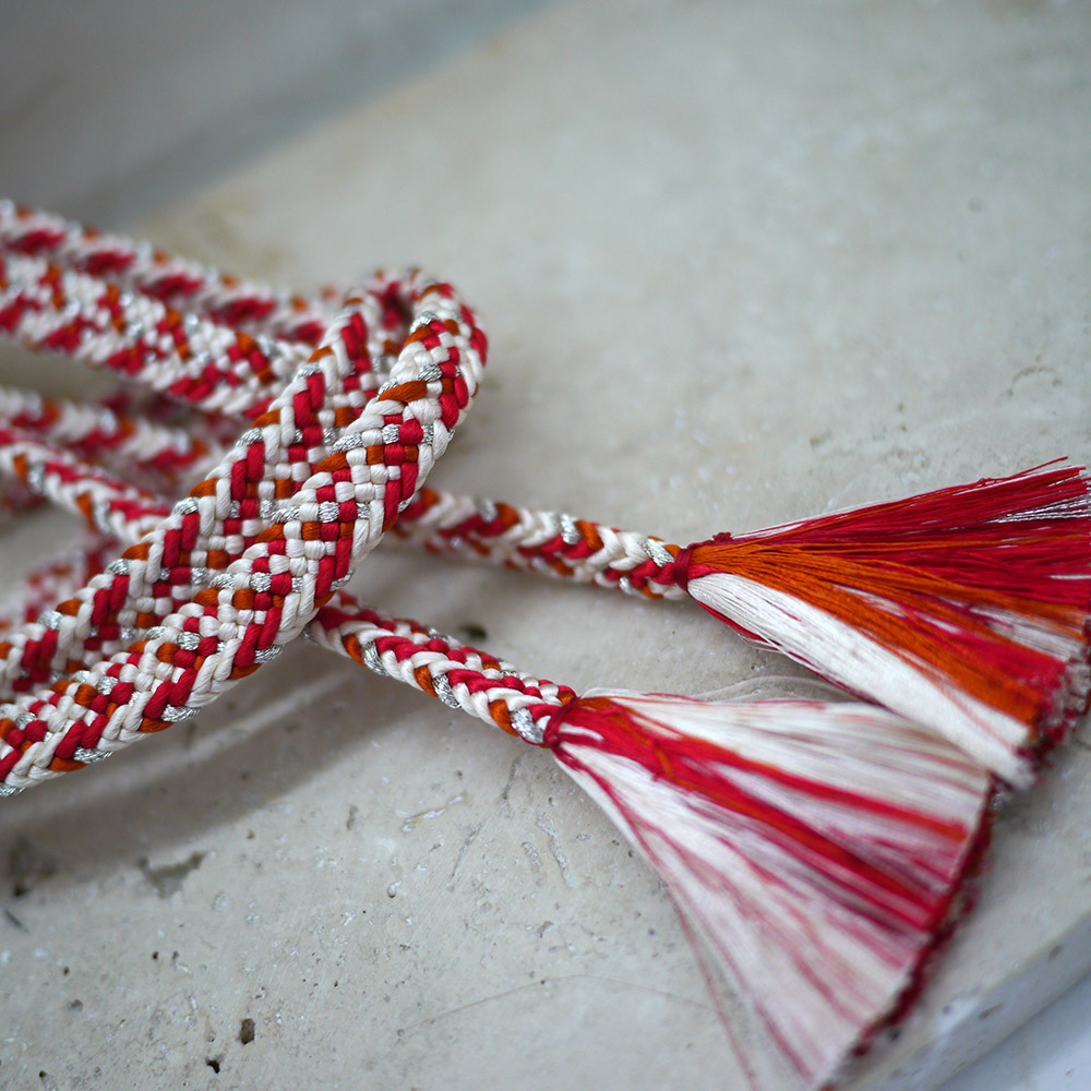 Photo rapprochée d'un obijime japonais en soie blanc et rouge