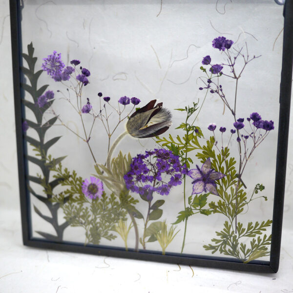 Détail d'un herbier artisanal fait de fleurs séchées violettes